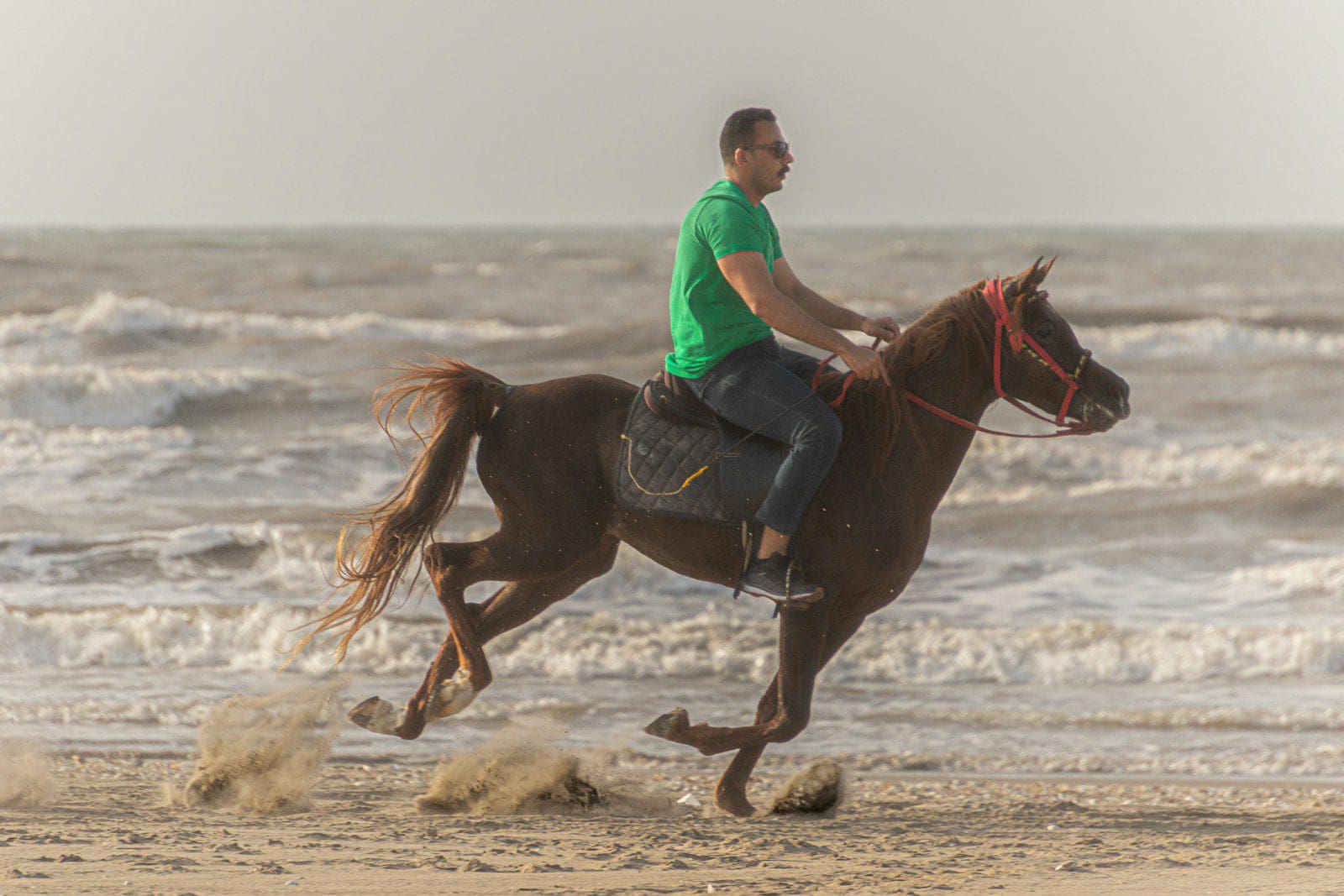 Photo by Michael Starkie a man riding a horse on the beach